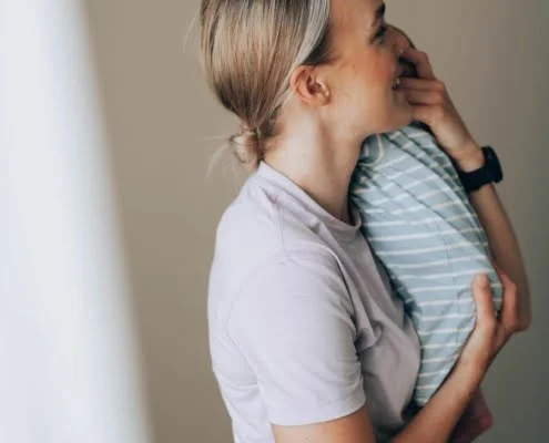 Synnytysvalmennus jossa nainen pitaa pienta vauvaa sylissaan.