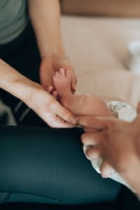 Vauvan osteopatia, osteopaatti hoitaa pienen vauvan jalkaa.