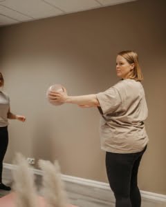 Aitiyspilates Helsingissa. Ohjaaja pitaa kadessaan palloa. Mama + Bebe -jooga