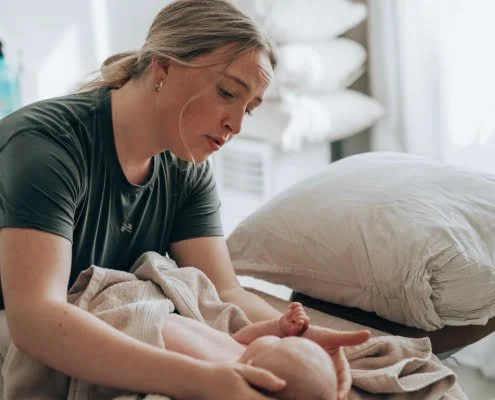 Vauvahieronta, hieroja katsoo lempeasti pienokaista.